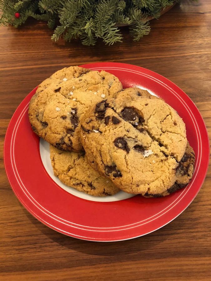 Three large sea-salted chocolate chip cookies on a red plate