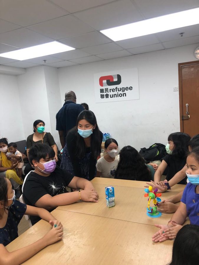 Jeanine teaching a group of children seated around a table at the Refugee Union in Hong Kong